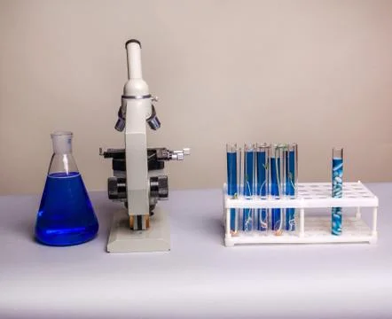 Laboratory metal microscope and test tubes with liquid Stock Photos