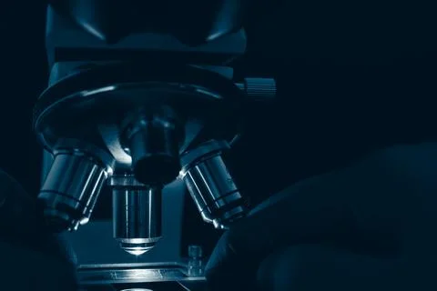 Laboratory optical microscope macro view with gloved hands Stock Photos