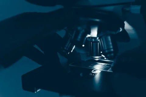 Laboratory optical microscope macro view with gloved hands Stock Photos