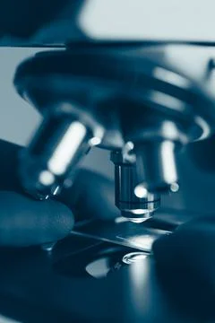Laboratory optical microscope macro view with gloved hands Stock Photos