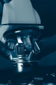Laboratory optical microscope macro view with gloved hands Stock Photos
