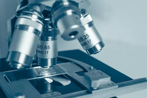Laboratory optical microscope macro view with gloved hands Stock Photos