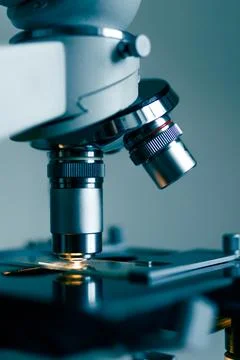 Laboratory optical microscope macro view with gloved hands Stock Photos
