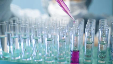 Laboratory pipette with a drop of liquid dripping into a test tube. Stock Footage 123672980