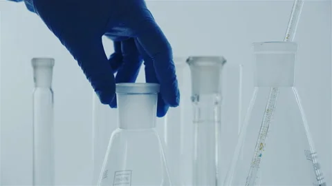 Laboratory research. Hands in blue gloves. Glass flask with a blue liquid. Stock Footage 142692780