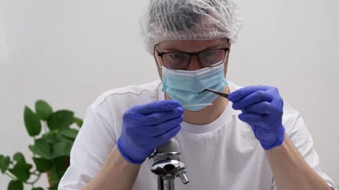 Laboratory researcher handling delicate sample with precision, wearing Vídeos de archivo 310429414