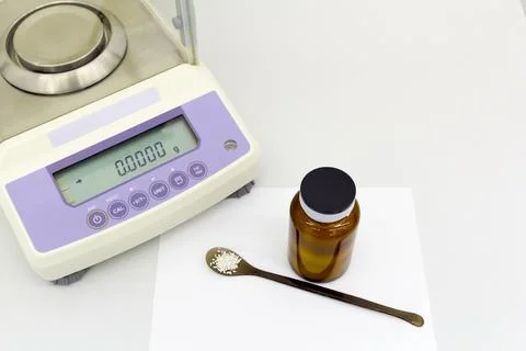 Laboratory scale on table with materials in bottle. Stock Photos