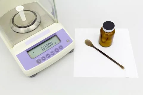 Laboratory scale on table with materials in bottles. Stock Photos