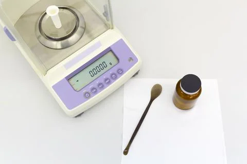 Laboratory scale on table with materials in bottles. Stock Photos