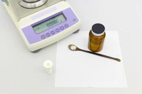 Laboratory scale on table with materials in bottles. Stock Photos