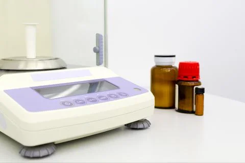 Laboratory scale on table with materials in bottles. Stock Photos