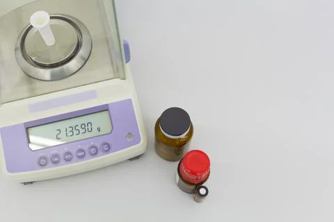 Laboratory scale on table with materials in bottles. Stock Photos