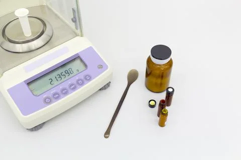 Laboratory scale on table with materials in bottles. Stock Photos