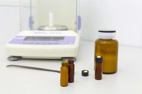 Laboratory scale on table with materials in bottles. Stock Photos