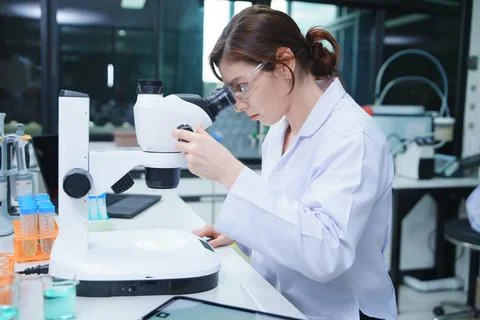 Laboratory Scientist Analyzing Samples with Microscope Фото