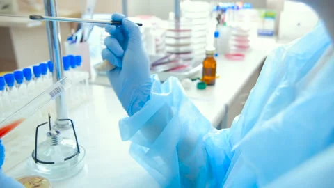 A laboratory scientist with a dispenser in his hands conducts experience or Stock Footage 100520987