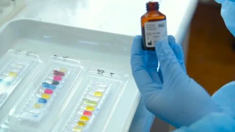 A laboratory scientist with a dispenser in his hands conducts experience or Stock-Footage 101425381