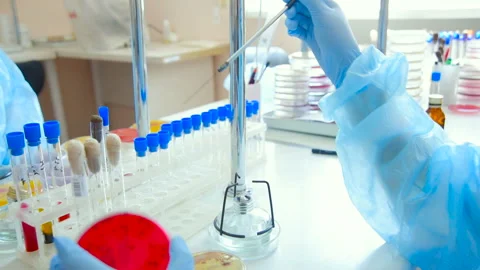 A laboratory scientist with a dispenser in his hands conducts experience or Stock Footage 101425926