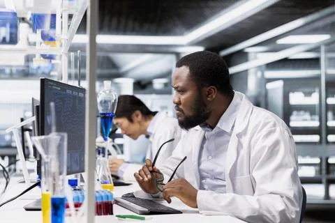 Laboratory scientist squinting eyes at computer, processing DNA patient data 스톡 사진