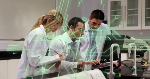 Laboratory scientists leaning and typing at computer, activating green overlay Stock Footage 330652769