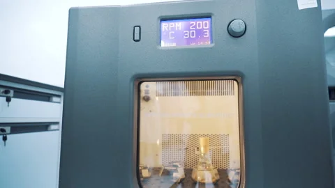 Laboratory Shaker machine shaking beaker medium shot pan left to right Vídeos de archivo 158667663