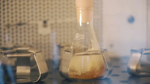 Laboratory Shaker machine shaking yellow liquid in erlenmeyer flask extra Stock Footage 158671372