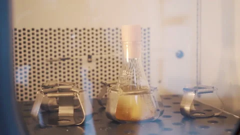 Laboratory Shaker machine shaking yellow liquid in erlenmeyer flask close up Video stock 158671699