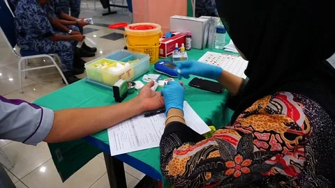 Laboratory staff is taking samples of the blood from the patient for screening Stock Footage 127020523