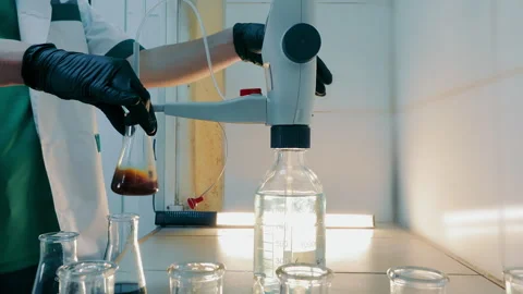 Laboratory Technician Adjusting Flask, Scientist adjusting a flask with a dark Stock Footage 265491048