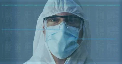 Laboratory technician analyzing log overlay in cleanroom, wearing hood coverall Foto stock