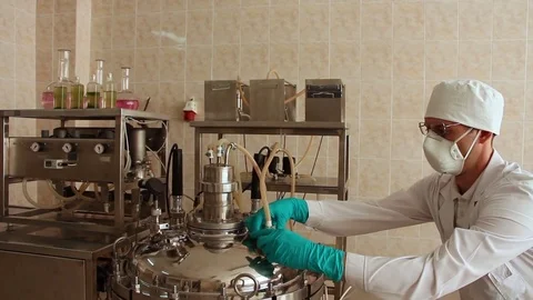 Laboratory technician assembles the connection of pipe on top of fermenter Stock Footage 78527405