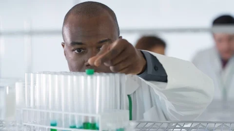 Laboratory technician checking chemical solution in test tubes in lab Stock Footage 107620933