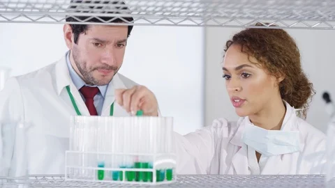 Laboratory technician checking chemical solution in test tubes in lab Stock Footage 107641204