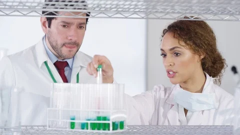 Laboratory technician checking chemical solution in test tubes in lab Stock Footage 107641285