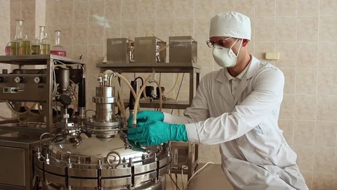 Laboratory technician disassembles the connection of pipe on top of fermenter Stock Footage 78527439