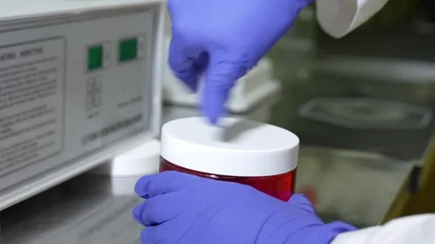 Laboratory Technician Handling a Sample Jar in a Controlled Environment for Stock Footage 304779802