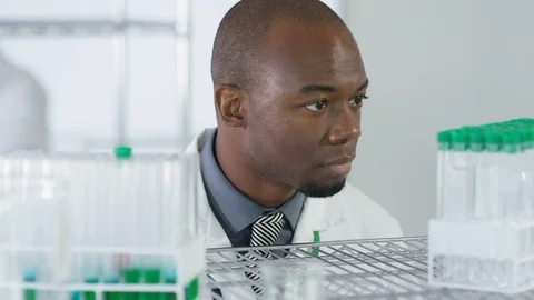 Laboratory technician inspecting chemical solution in test tubes in lab Stock Footage 107621548
