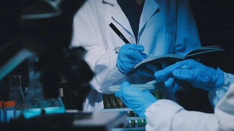 A laboratory technician makes microscopic bacteriological examination with .. Stock Footage 336485725