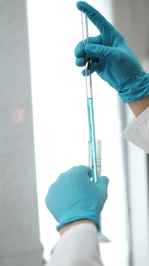Laboratory Technician Measuring Blue Liquid With Graduated Pipette Stock Footage 345558940