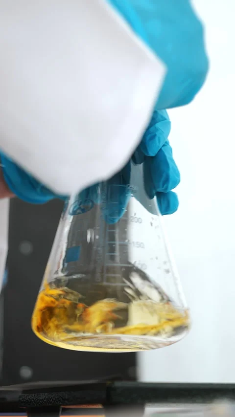 Laboratory Technician Mixing Liquid in Erlenmeyer Flask Stock Footage 345560810