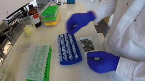 Laboratory technician operating a tissue lyser II machine Vídeos de archivo 109315637