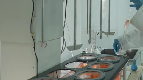 Laboratory technician in protective clothing taking chemical samples from Stock Footage 278259890