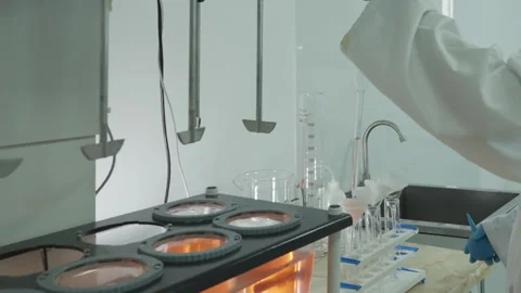 Laboratory technician in protective clothing taking chemical samples from Stock Footage 308452514