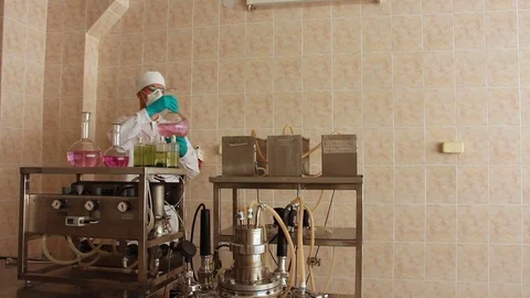 Laboratory technician takes big flask from steel rack Stock Footage 78527488