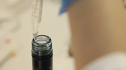 Laboratory technician taking sample from bottle of wine for pipette 스톡 동영상 64772585