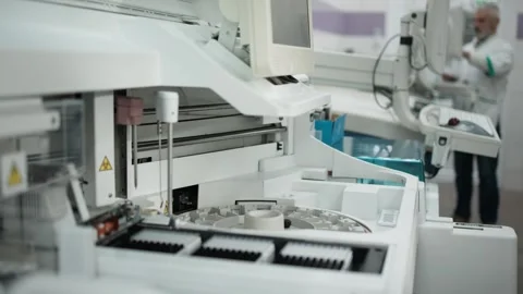 Laboratory technician in white coat operates advanced testing equipment, Stock Footage 334884647