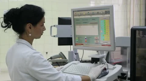 Laboratory technician work at computer of automated device for blood test Stock Footage 12448888