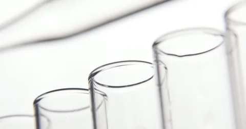 Laboratory test. Pipette drips transparent chemicals into test tubes in a row on Stock Footage 106200906