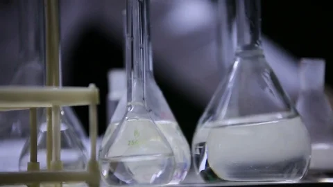 Laboratory test tubes in the background a man writes. Stock Footage 72153258