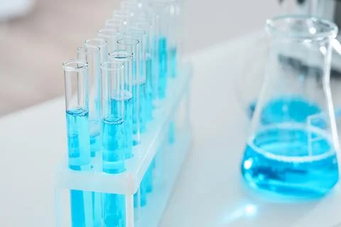 Laboratory test tubes with blue liquid and erlenmeyer flask, scientific resea Stock Photos
